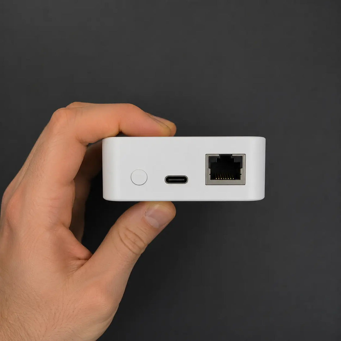 vploq Home held between two fingers, side profile